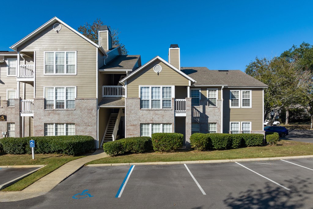 an apartment building with a parking lot and a building with balconies