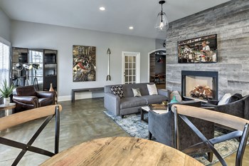 Community clubhouse with a couch, two chairs, and a TV at Retreat at the Park apartments for rent - Photo Gallery 4