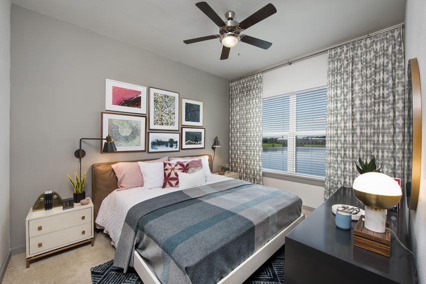 Bedroom with ceiling fan, window, and carpet flooring at Ravella at Town Center in Jacksonville, FL - Photo Gallery