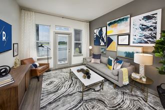 Living room with wood-designed flooring and adjacent patio at Ravella at Town Center in Jacksonville, FL