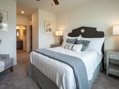 Furnished bedroom with ceiling fan and carpet flooring at The Station at Brighton apartments for rent in Grovetown, GA