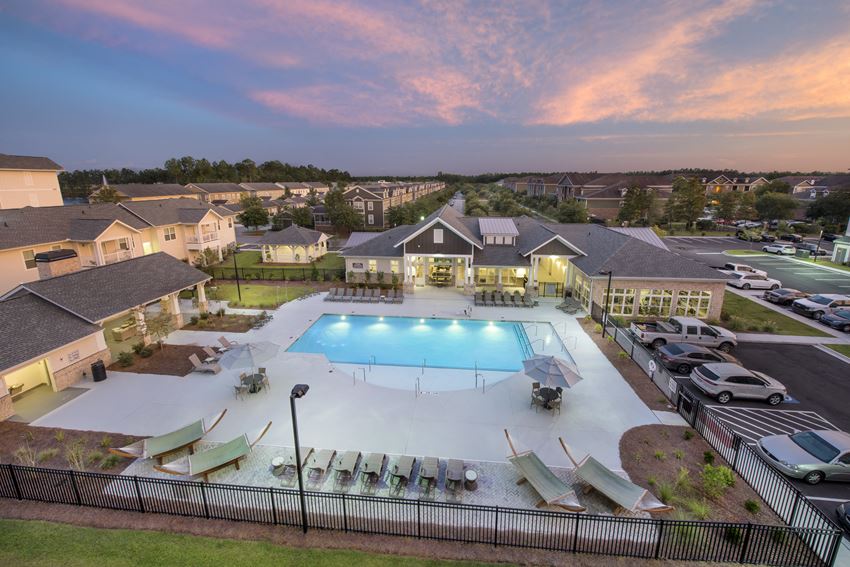 Aerial view of the Station at Savannah Quarters swimming pool, clubhouse, and community at twilight - Photo Gallery 1