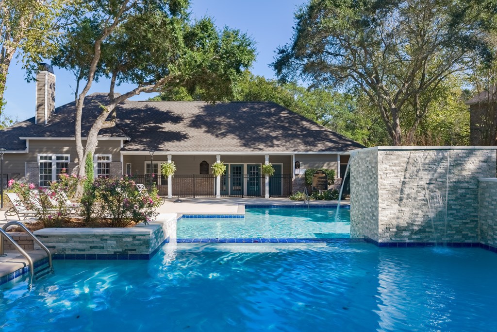 a swimming pool in front of a house with a pool