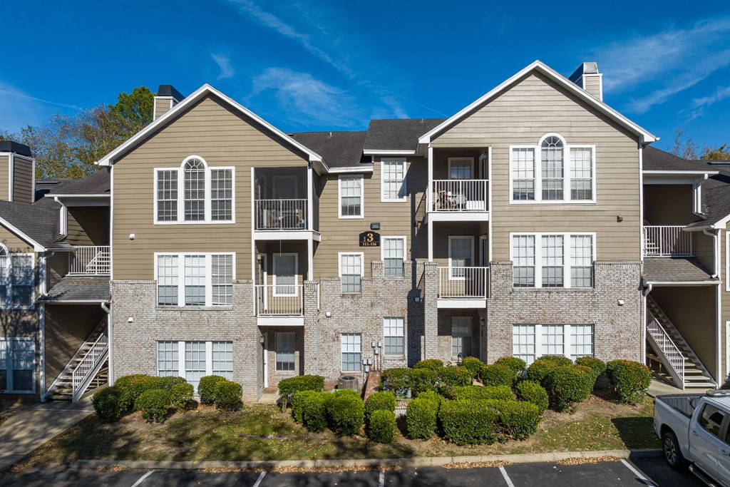 an exterior view of an apartment building with balconies and shrubs