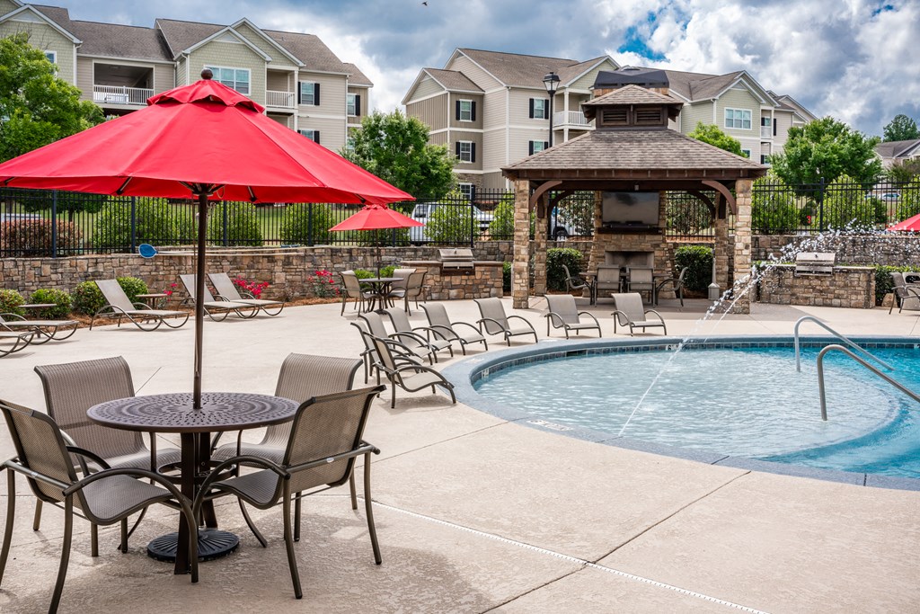 Outdoor swimming pool with deck and pavilion at Riverstone apartments for rent