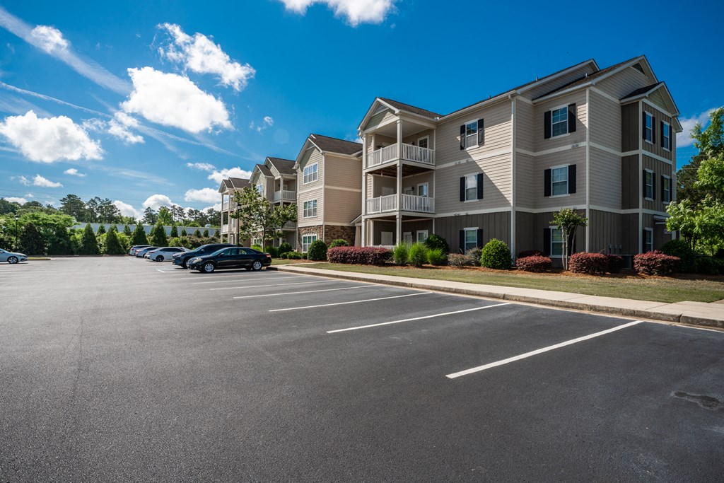 Three-story residential building with surface lot parking at Riverstone apartments for rent in Macon, GA