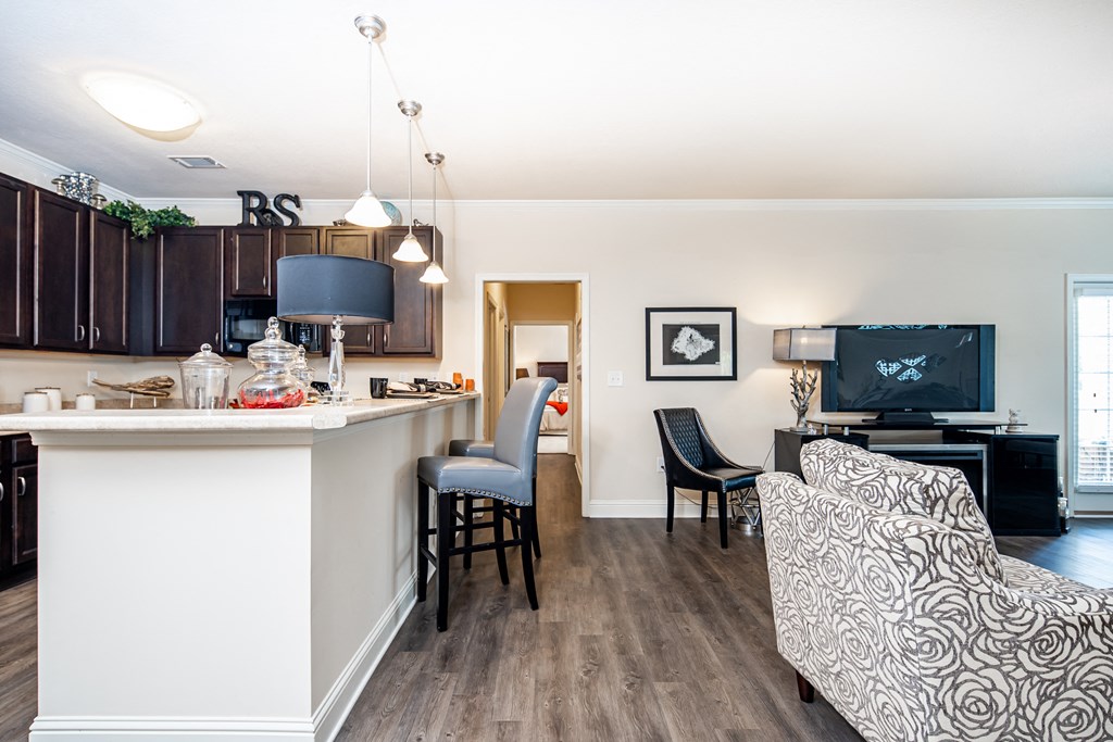 View of kitchen, breakfast bar, living room, and hallway to bedroom at Riverstone apartments for rent in Macon, GA