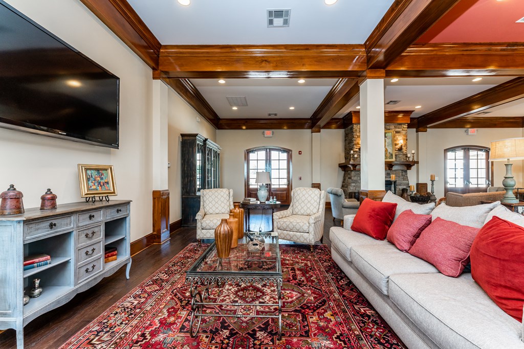 Interior of the resident clubhouse with sofa, chairs and large TV at Riverstone apartments for rent in Macon, GA