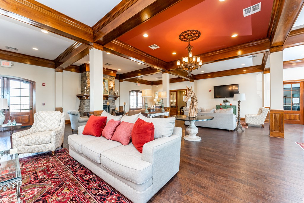 Large clubhouse with ample seating areas, high ceilings, and wood flooring at Riverstone apartments for rent in Macon, GA