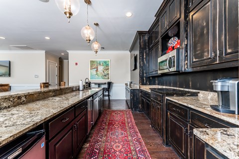 a large kitchen with granite counter tops and black cabinets