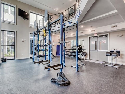a gym with weights and cardio equipment in a building with glass doors