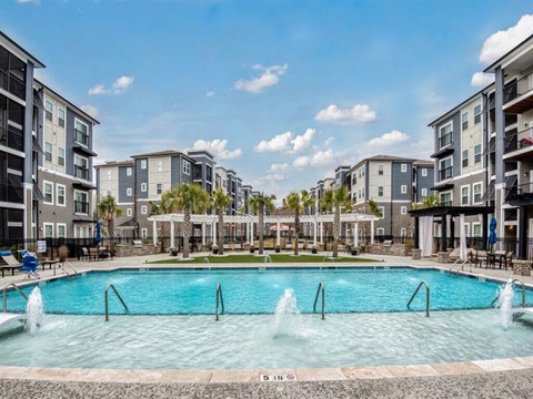 a large swimming pool with apartments in the background