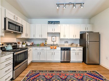 Large kitchen with extensive cabinet space, stainless steel appliances, and granite-style counters at Exchange at Windsor Hill in North Charleston, SC - Photo Gallery 2