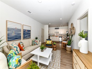 Furnished living room with ample seating and view of kitchen at Exchange at Windsor Hill apartments for rent