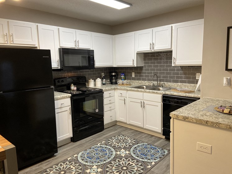 fayetteville NC apartment kitchen with white cabinets and black appliances