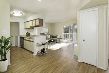 Apartment living space with open kitchen and wood-designed flooring at Springwoods at Lake Ridge - Photo Gallery 21