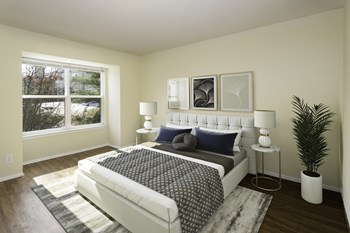 Bedroom with large window and wood-designed flooring at Springwoods at Lake Ridge - Photo Gallery 24