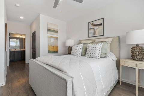 a white bedroom with a large bed and a bathroom