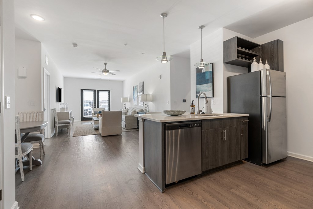 a kitchen and living room with a stainless steel refrigerator and counter top