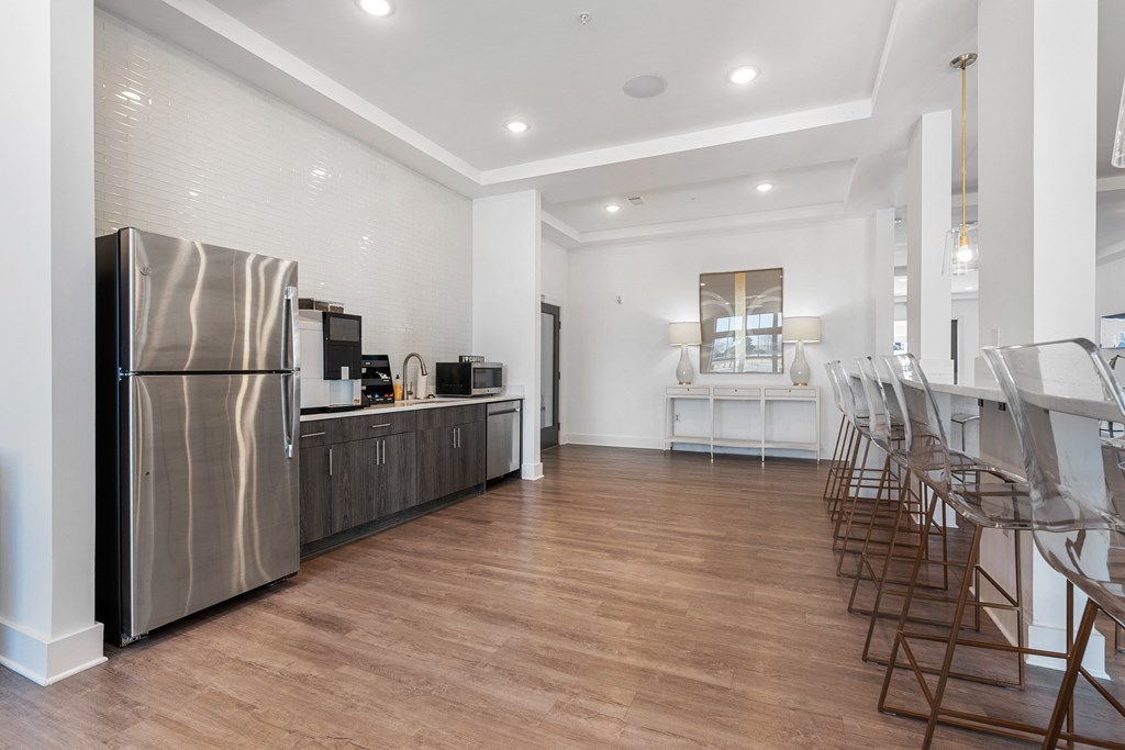 a kitchen and dining room with a refrigerator and chairs