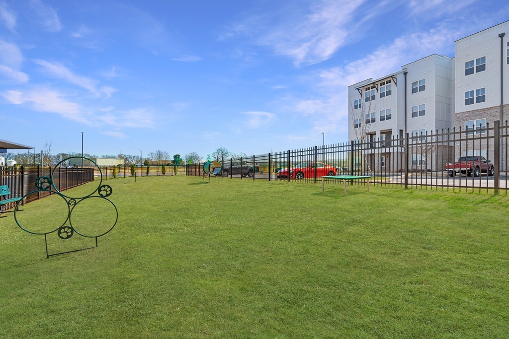 a large yard with a tennis court in front of a building