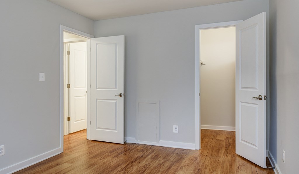 Bedroom with wood-designed flooring and walk-in closet at Stonecreek Club in Germantown, MD