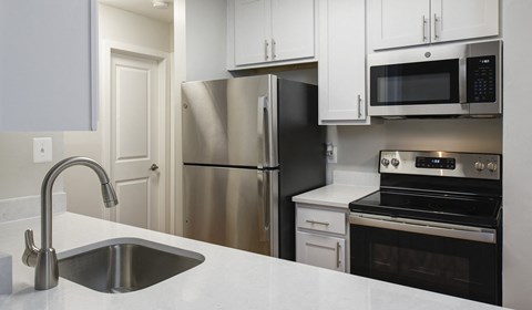 a kitchen with stainless steel appliances and white cabinets