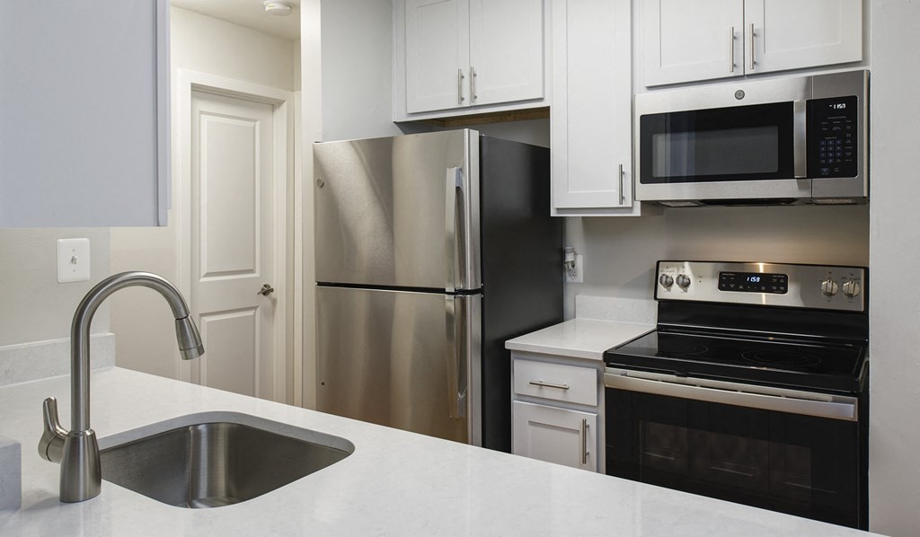 Kitchen with granite-style counters, stainless steel appliances, and shaker-style cabinets at Stonecreek Club in Germantown, MD