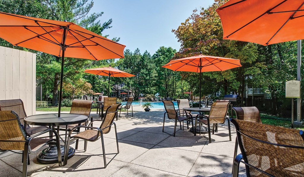 seating and tables around the swimming pool for apartment rentals at Hunt Club in Gaithersburg, MD