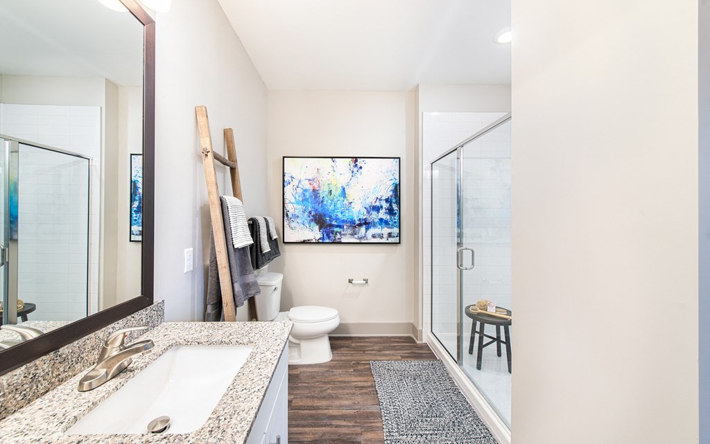 Bathroom with wood-designed flooring andwalk-in shower at The Highland apartments for rent in Augusta, GA