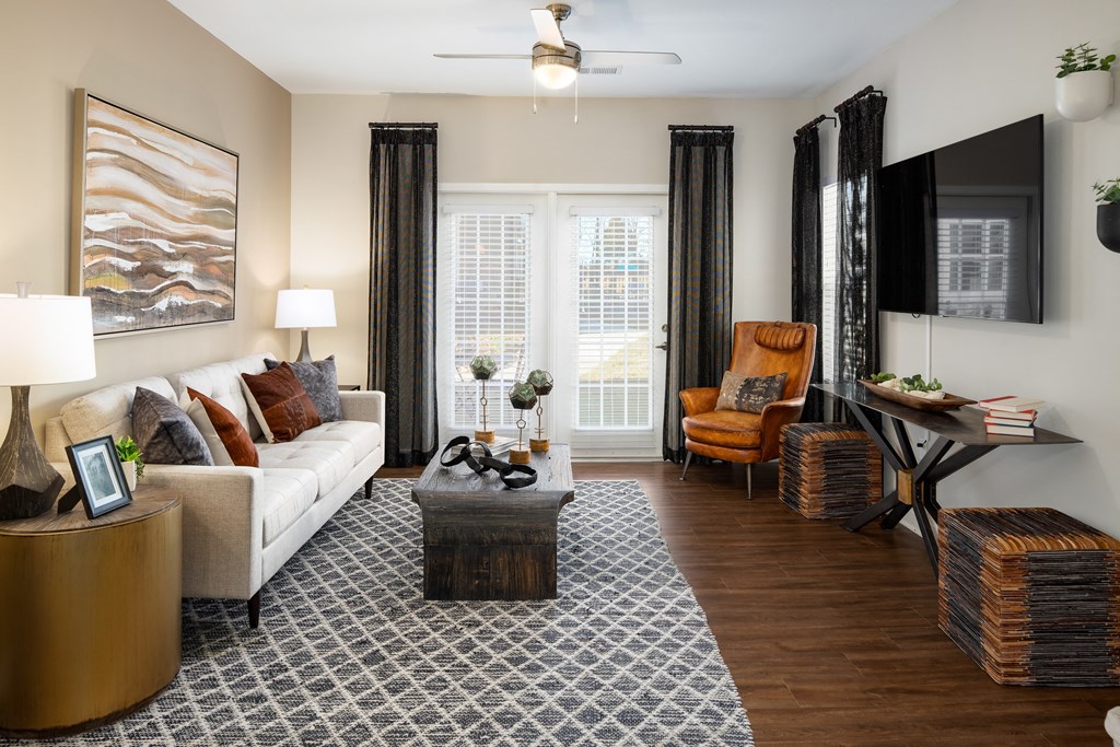 Furnished living room with a sofa, two nightstands, coffee table and wood-designed flooring at The Alexandria in Madison, AL