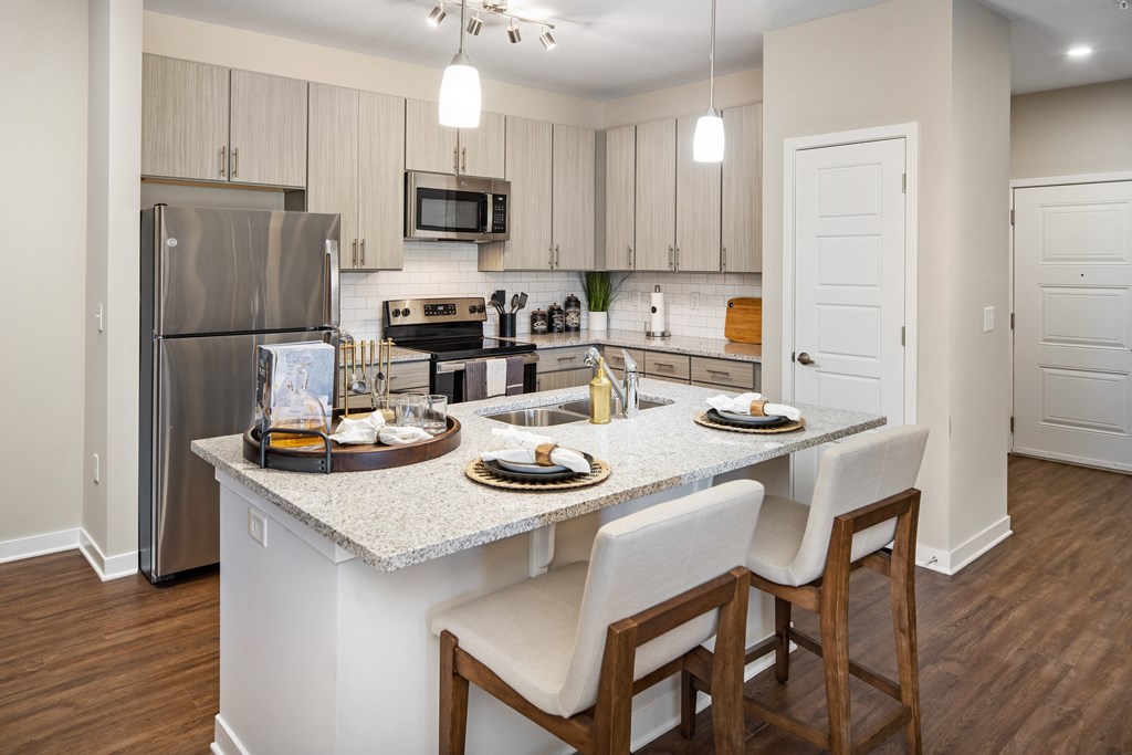 Madison, AL apartment kitchen with island bar and granite countertops at The Alexandria