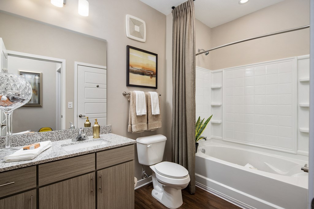 Madison, AL apartment laundry room area with a full-size washer, dryer, and miscellaneous white shelf at The Alexandria