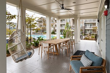 Clubhouse patio with seating and swinging chairs at The Highland in Augusta, GA - Photo Gallery 17