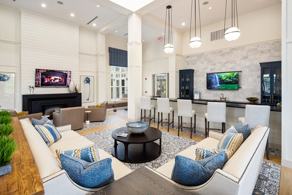 Resident clubhouse with lounge seating, TVs, and communal kitchen at The Highland in Augusta, GA