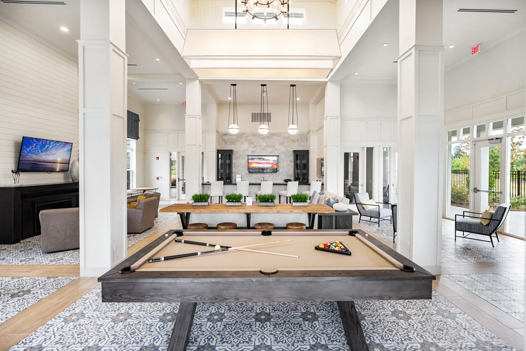 Resident clubhouse with billiard table, communal kitchen, and lounge area with TV at The Highland in Augusta, GA