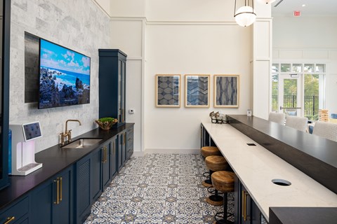a kitchen with blue cabinets and a long counter with stools