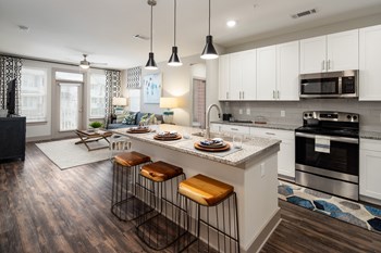 Open-concept living room and kitchen with island bar at The Highland in Augusta, GA - Photo Gallery 20