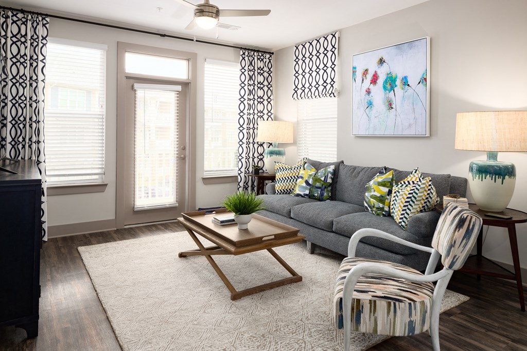 Living room with wood-designed flooring and door to patio at The Highland in Augusta, GA