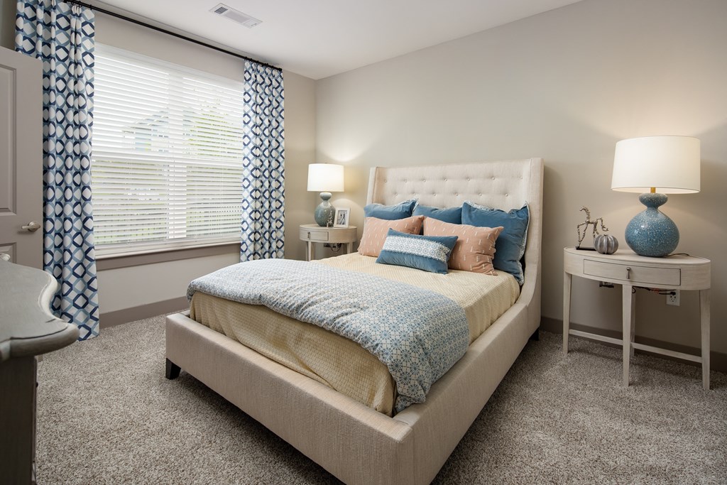 Bedroom with large window and carpet flooring at The Highland in Augusta, GA