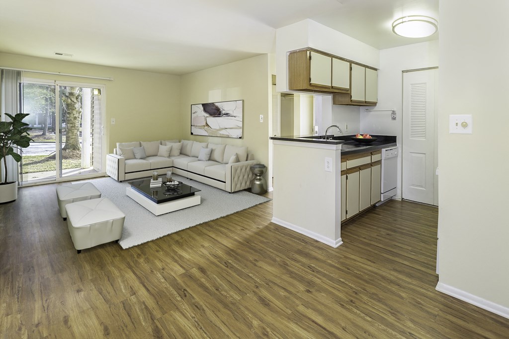 Living area and kitchen with wood-designed flooring at Windsor Park in Woodbridge, VA