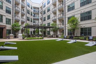Foundry Yards apartment community outdoor space with yard games and grilling stations. - Photo Gallery