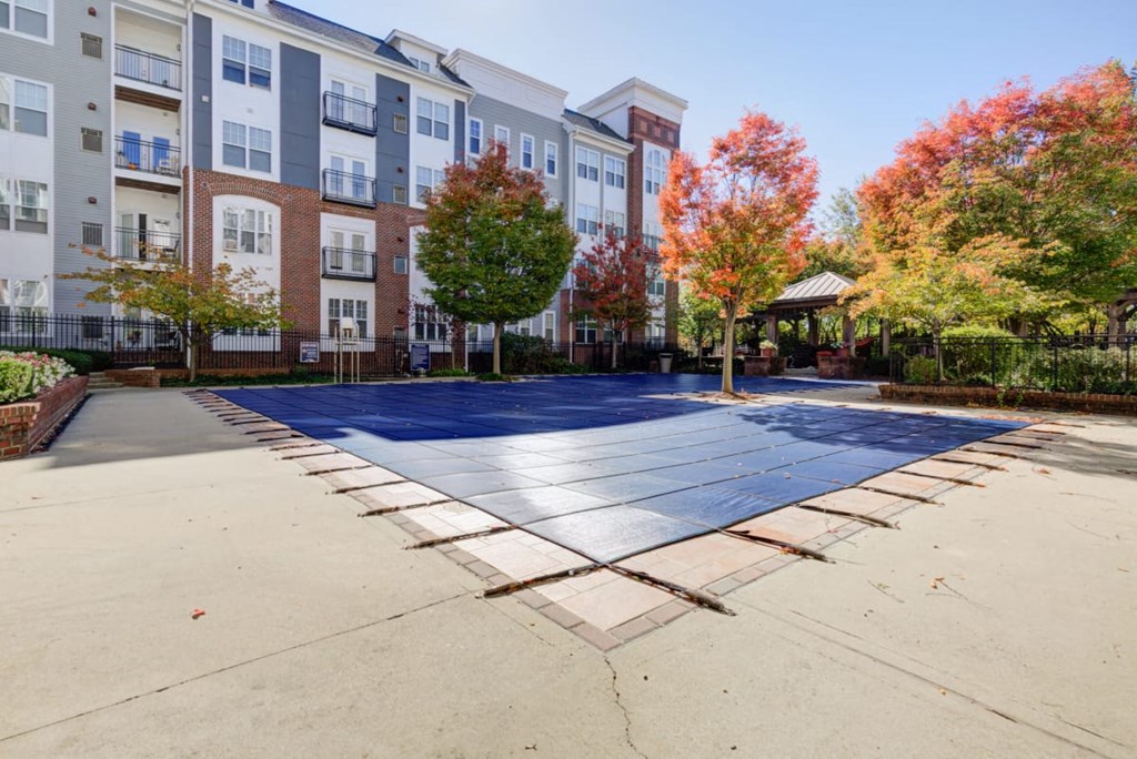 a blue tennis court in front of an apartment building