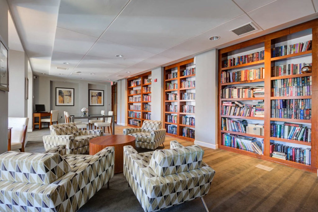 the library in the hotel is full of books and chairs
