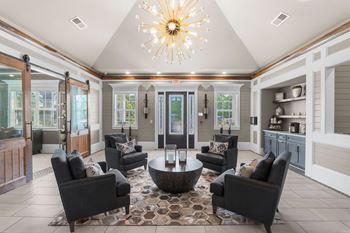 A living room with a large chandelier and a rug.