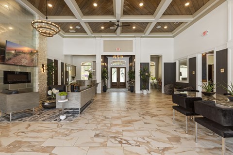 A spacious lobby with a marble floor and a fireplace.