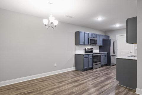 A kitchen with a grey cabinet and a white wall.