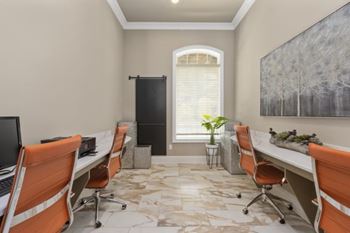 A room with orange chairs and a painting on the wall.