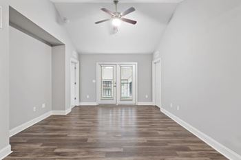 A room with a ceiling fan and a door with a window.