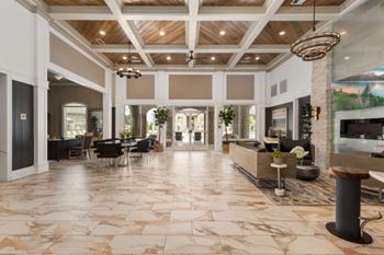 A spacious lobby with a marble floor and a large chandelier.